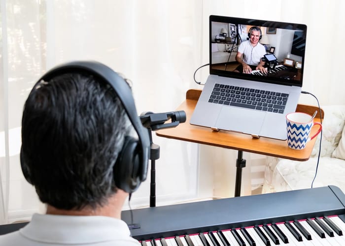 Adult taking an online piano lesson at home