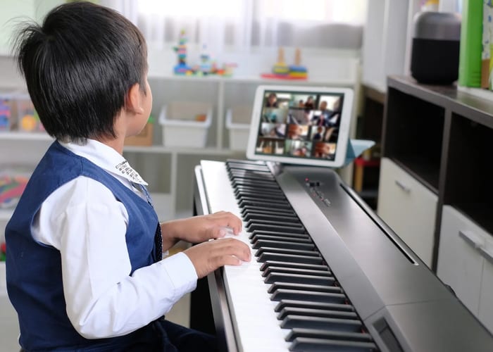 Child learning piano online via video call